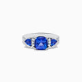 The Nahla Siri 14K White Gold Tanzanite and Diamond Ring showcases a large cushion-cut tanzanite center stone, flanked by two smaller tanzanites and accented with round diamonds along the band.