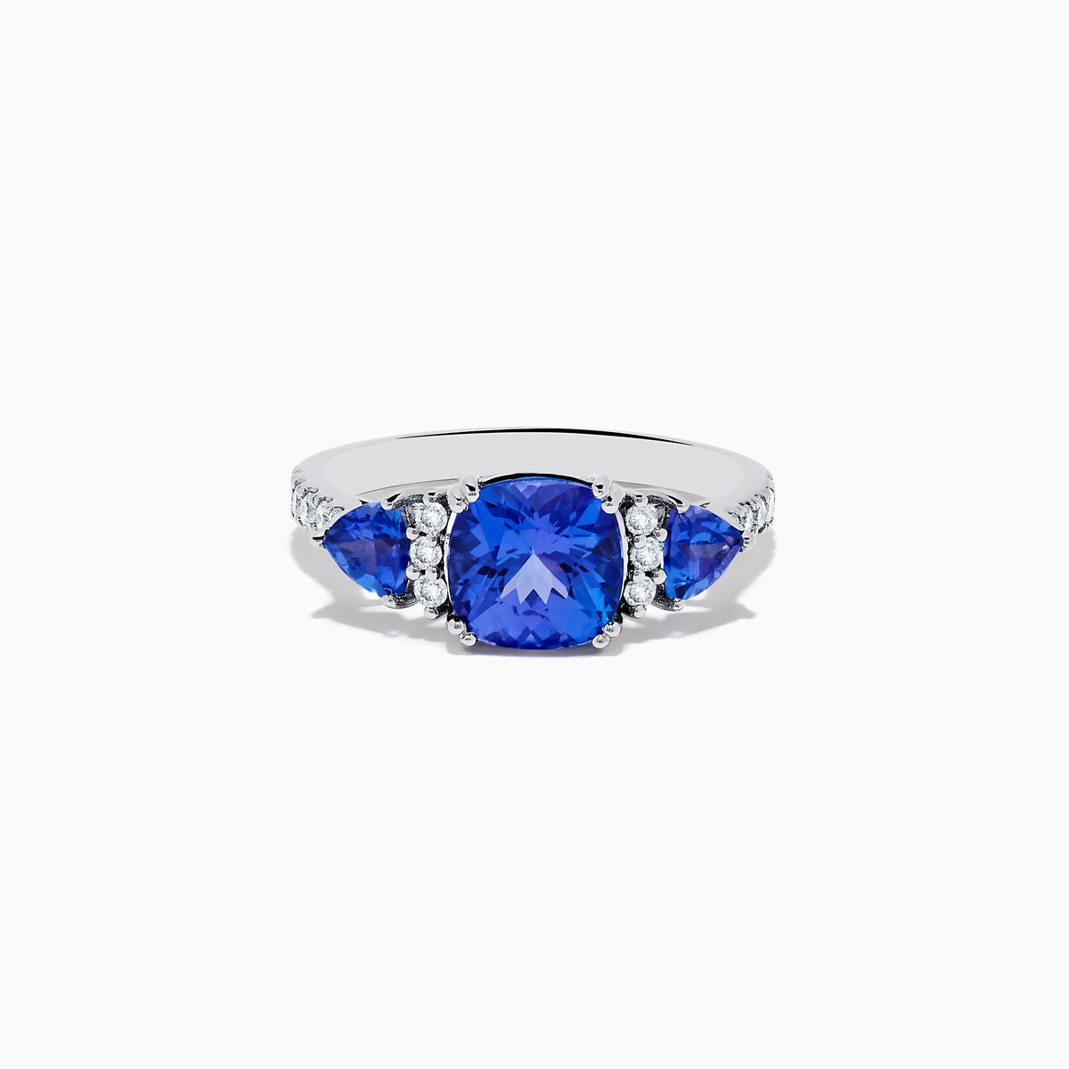 The Nahla Siri 14K White Gold Tanzanite and Diamond Ring showcases a large cushion-cut tanzanite center stone, flanked by two smaller tanzanites and accented with round diamonds along the band.