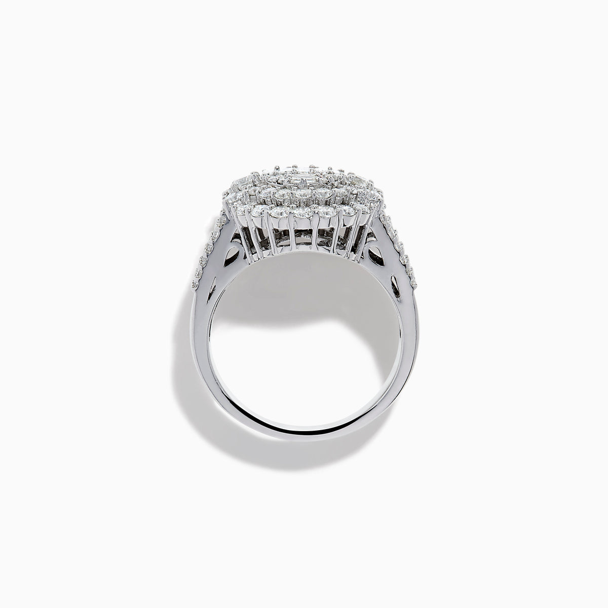The 14K White Gold Diamond Cluster Ring showcases rectangular and round-cut diamonds in an oval setting with two halo layers on a diamond-accented split shank band.