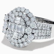 The 14K White Gold Diamond Cluster Ring showcases rectangular and round-cut diamonds in an oval setting with two halo layers on a diamond-accented split shank band.