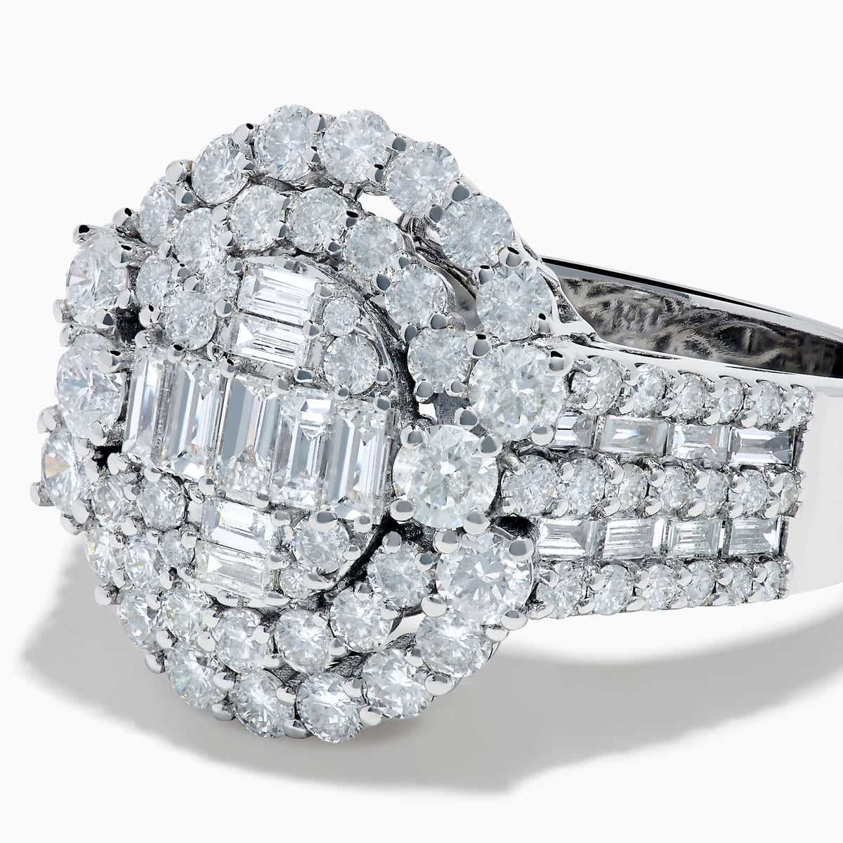 The 14K White Gold Diamond Cluster Ring showcases rectangular and round-cut diamonds in an oval setting with two halo layers on a diamond-accented split shank band.
