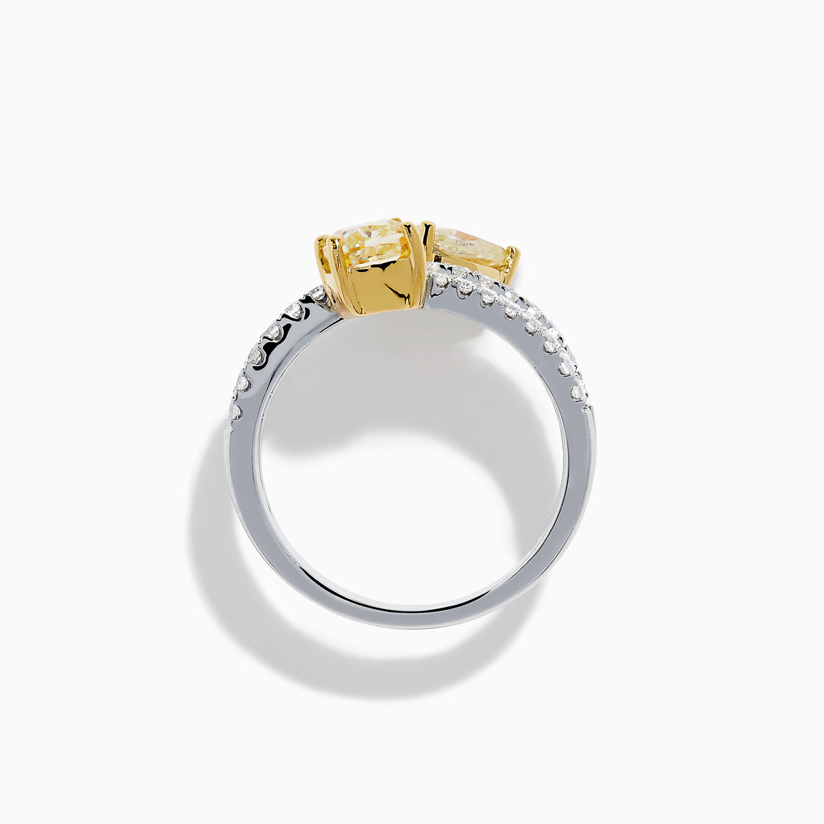 The Canare 18K Two Tone White and Yellow Diamond Bypass Ring features a spiral design with a row of small white diamonds, highlighted by yellow cushion-cut and pear-shaped diamonds set in yellow gold prongs.