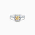 The Canare 18K Two Tone Gold White and Yellow Diamond Ring showcases a cushion-cut yellow diamond center, haloed by white diamonds, with a diamond-adorned band.