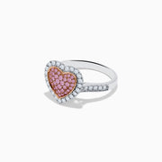 The Novelty 14K Two Tone Gold Pink and White Diamond Heart Ring features a heart-shaped centerpiece set with pink and white diamonds, accented by a sparkling border of clear, white stones.