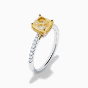 The Canare 18K Two Tone White and Yellow Diamond Ring features a cushion-cut yellow diamond centerpiece accented by small round white diamonds along the band.