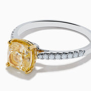 The Canare 18K Two Tone White and Yellow Diamond Ring features a cushion-cut yellow diamond centerpiece accented by small round white diamonds along the band.