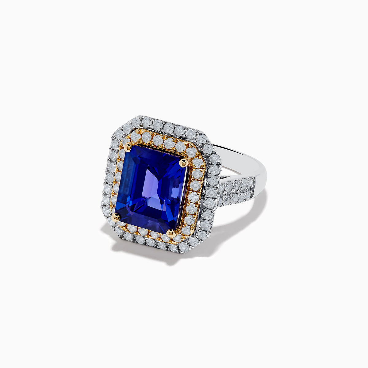The Nahla Siri 14K Two Tone Gold Tanzanite and Diamond Ring features a rectangular tanzanite with a double halo of white and yellow diamonds, set in a two-tone gold band, shown against a white background.