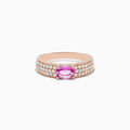 The 14K Rose Gold Pink Sapphire and Diamond Ring showcases a central oval pink sapphire, accented by rows of sparkling round diamonds along the band.