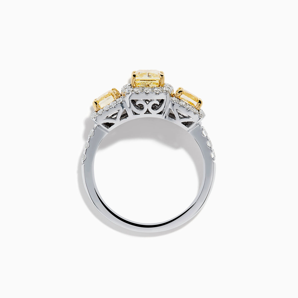 The Canare 18K Two Tone White and 3 Stone Yellow Diamond Ring showcases three rectangular yellow diamonds, each haloed with sparkling diamonds, set on a diamond-studded white gold band.