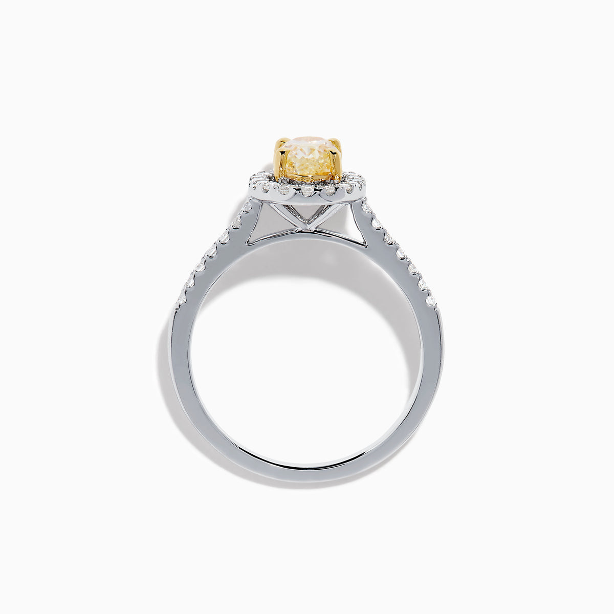 The Canare 18K Two Tone White and Yellow Diamond Ring features an oval yellow diamond center, surrounded by a halo of round white diamonds with extra diamonds adorning the band.