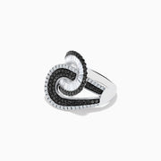 The 14K White Gold Black and White Diamond Swirl Ring features an abstract interlocking design with alternating rows of black and white diamonds in a bold, modern setting.