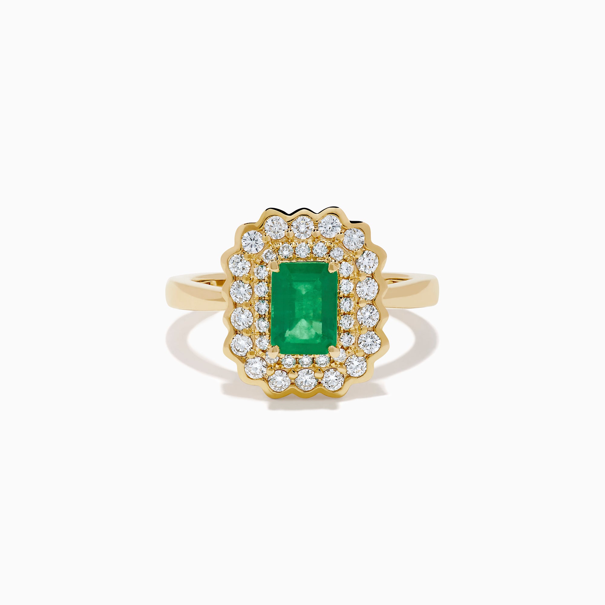 The Brasilica 14K Yellow Gold Emerald and Diamond Double Halo Ring showcases a rectangular green emerald at the center, accented by two rows of sparkling round white diamonds in an elegant scalloped halo design.