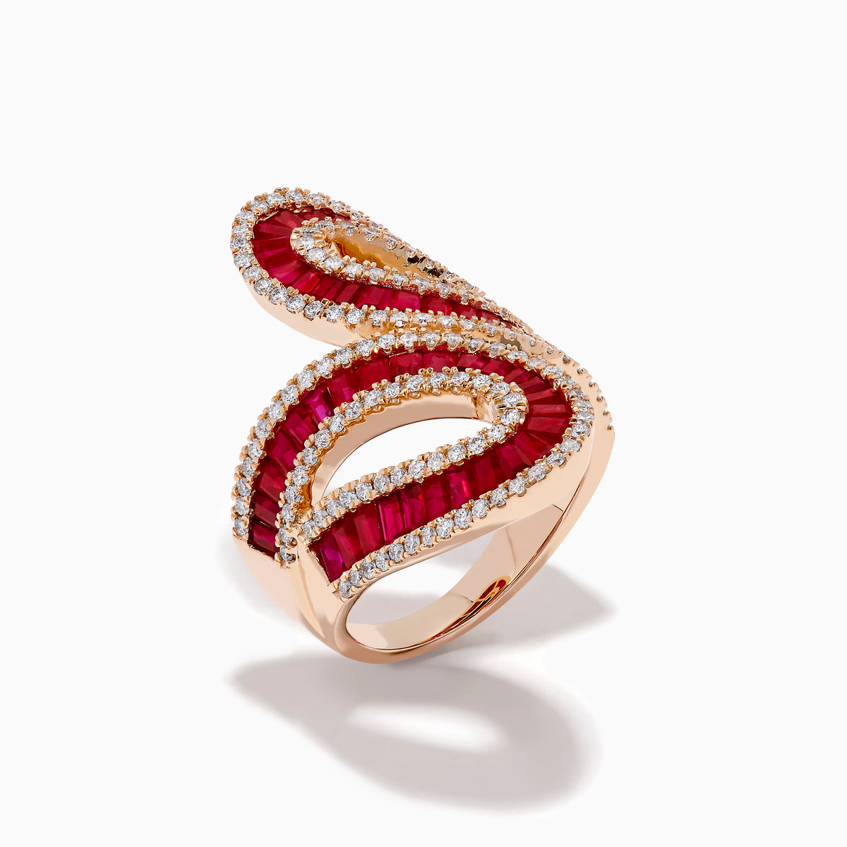 The 14K Rose Gold Ruby and Diamond Bypass Statement Ring features two overlapping rose gold loops adorned with rows of rubies and bordered by sparkling diamonds, creating an elegant and luxurious look against a plain white background.