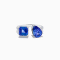 The Nahla Siri 14K White Gold Tanzanite and Diamond Toi Et Moi Ring features two blue tanzanite stones—one square-cut, one pear-shaped—side by side with diamond accents on the band, shown on a white background.