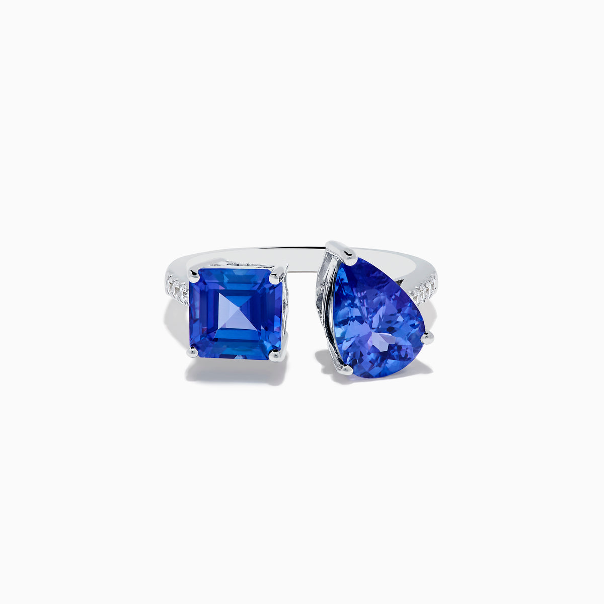 The Nahla Siri 14K White Gold Tanzanite and Diamond Toi Et Moi Ring features two blue tanzanite stones—one square-cut, one pear-shaped—side by side with diamond accents on the band, shown on a white background.