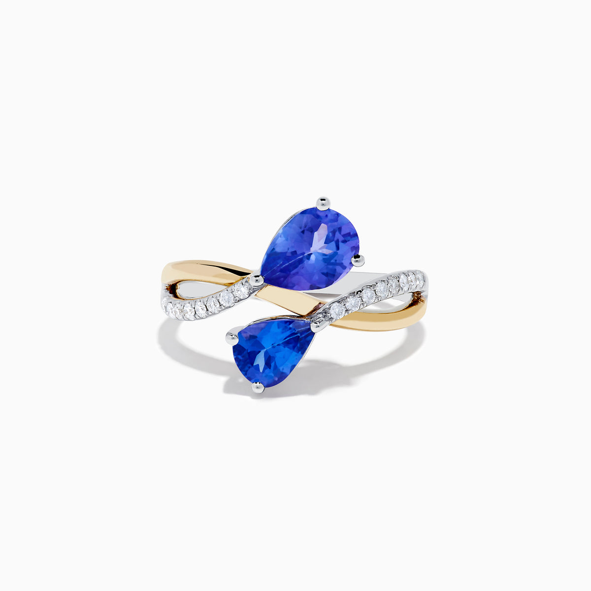 The Nahla 14K Two Tone Gold Tanzanite and Diamond Bypass Ring features two pear-shaped tanzanites and a curved band with sparkling white diamonds, displayed against a white background.