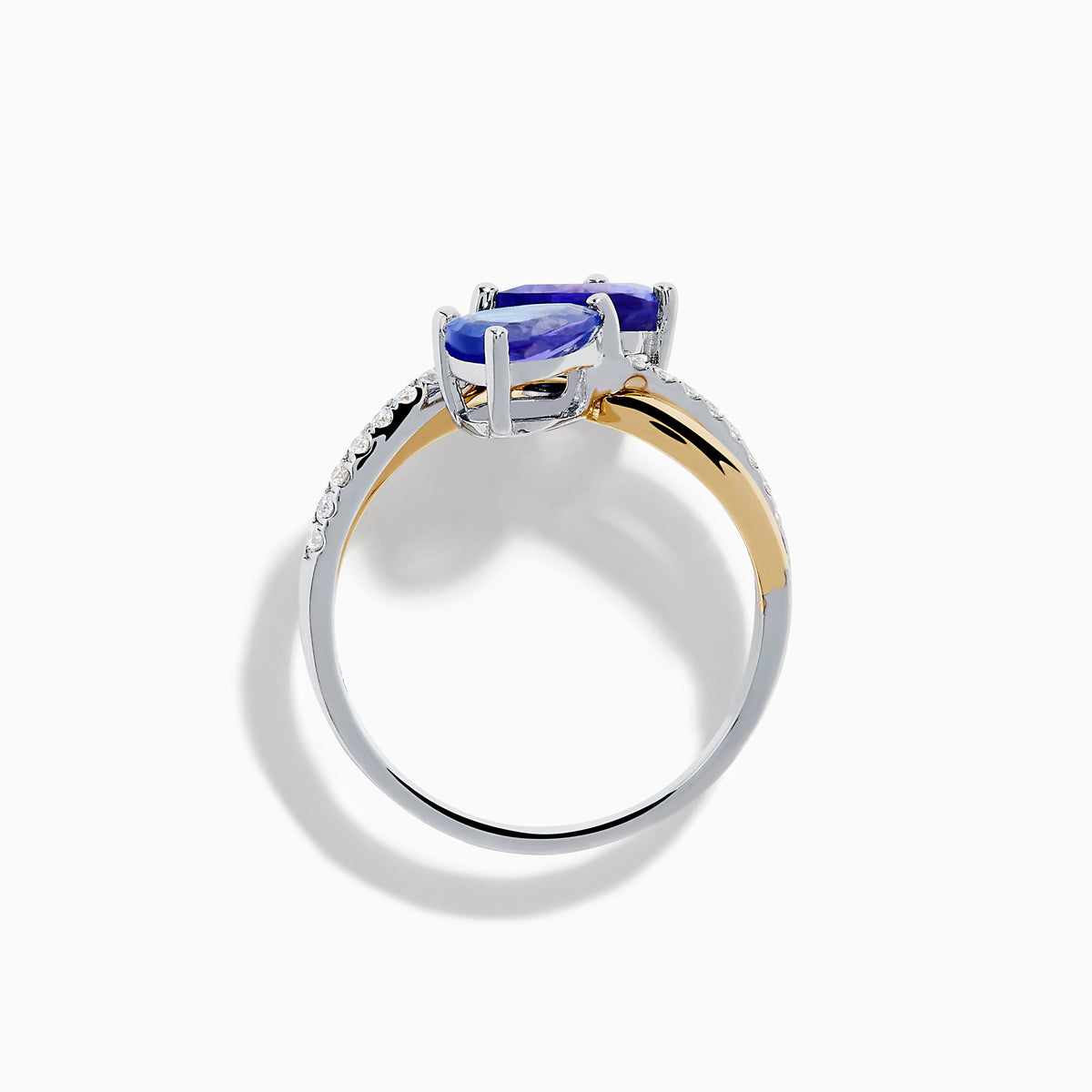 The Nahla 14K Two Tone Gold Tanzanite and Diamond Bypass Ring features two pear-shaped tanzanites and a curved band with sparkling white diamonds, displayed against a white background.