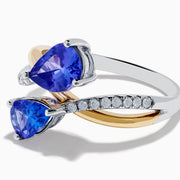 The Nahla 14K Two Tone Gold Tanzanite and Diamond Bypass Ring features two pear-shaped tanzanites and a curved band with sparkling white diamonds, displayed against a white background.