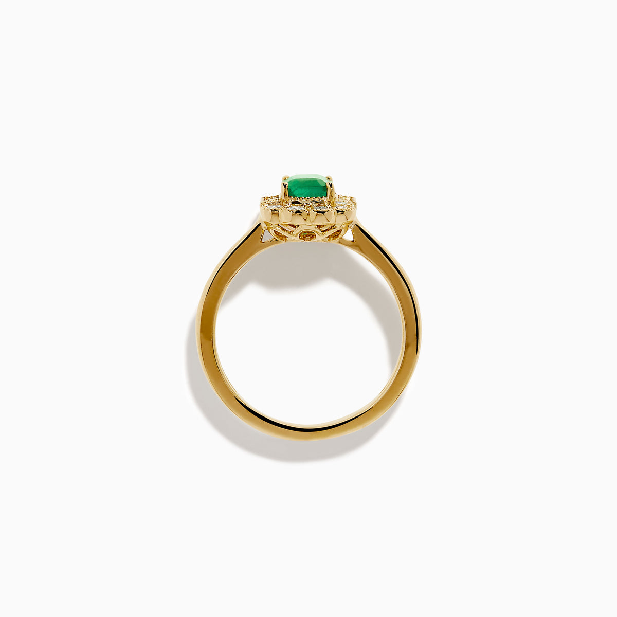 The 14K Yellow Gold Emerald and Diamond Halo Vintage Ring features an emerald-cut green center stone, accented by round and baguette white diamonds in a vintage halo setting.