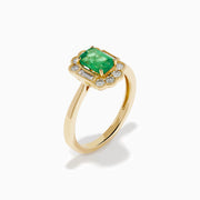 The 14K Yellow Gold Emerald and Diamond Halo Vintage Ring features an emerald-cut green center stone, accented by round and baguette white diamonds in a vintage halo setting.