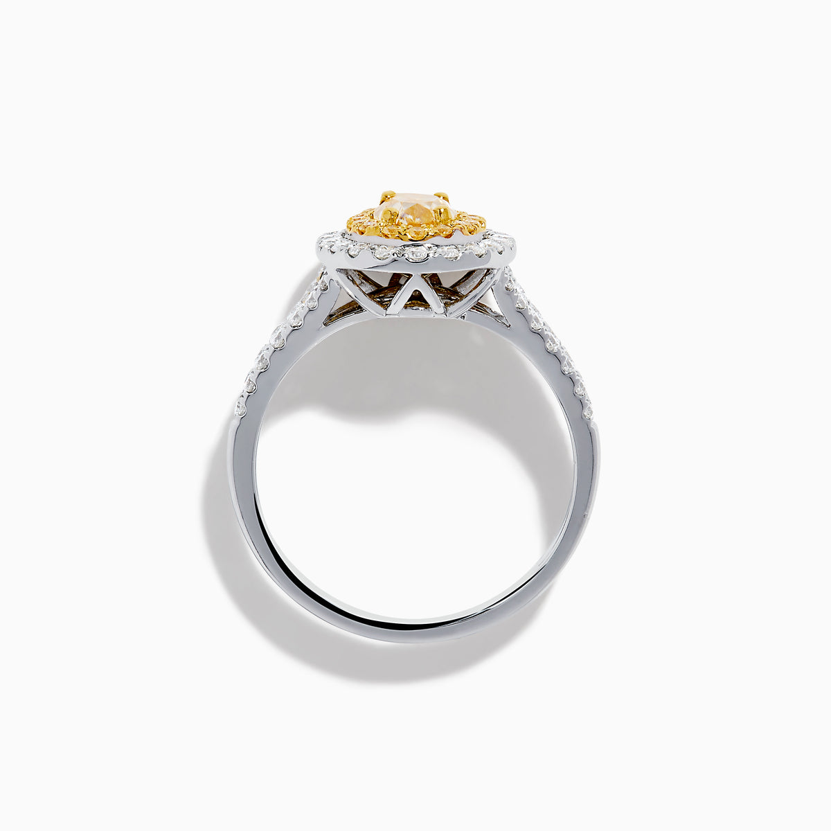 The Canare 18K Two Tone Gold White and Yellow Oval Diamond Split Shank Ring showcases an oval yellow diamond center with a double halo of white diamonds and a diamond-accented split shank, displayed on a plain white background.