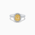 The Canare 18K Two Tone Gold White & Yellow Diamond Ring features a central oval yellow gemstone, accented by a halo of white diamonds and additional diamonds set along the band.