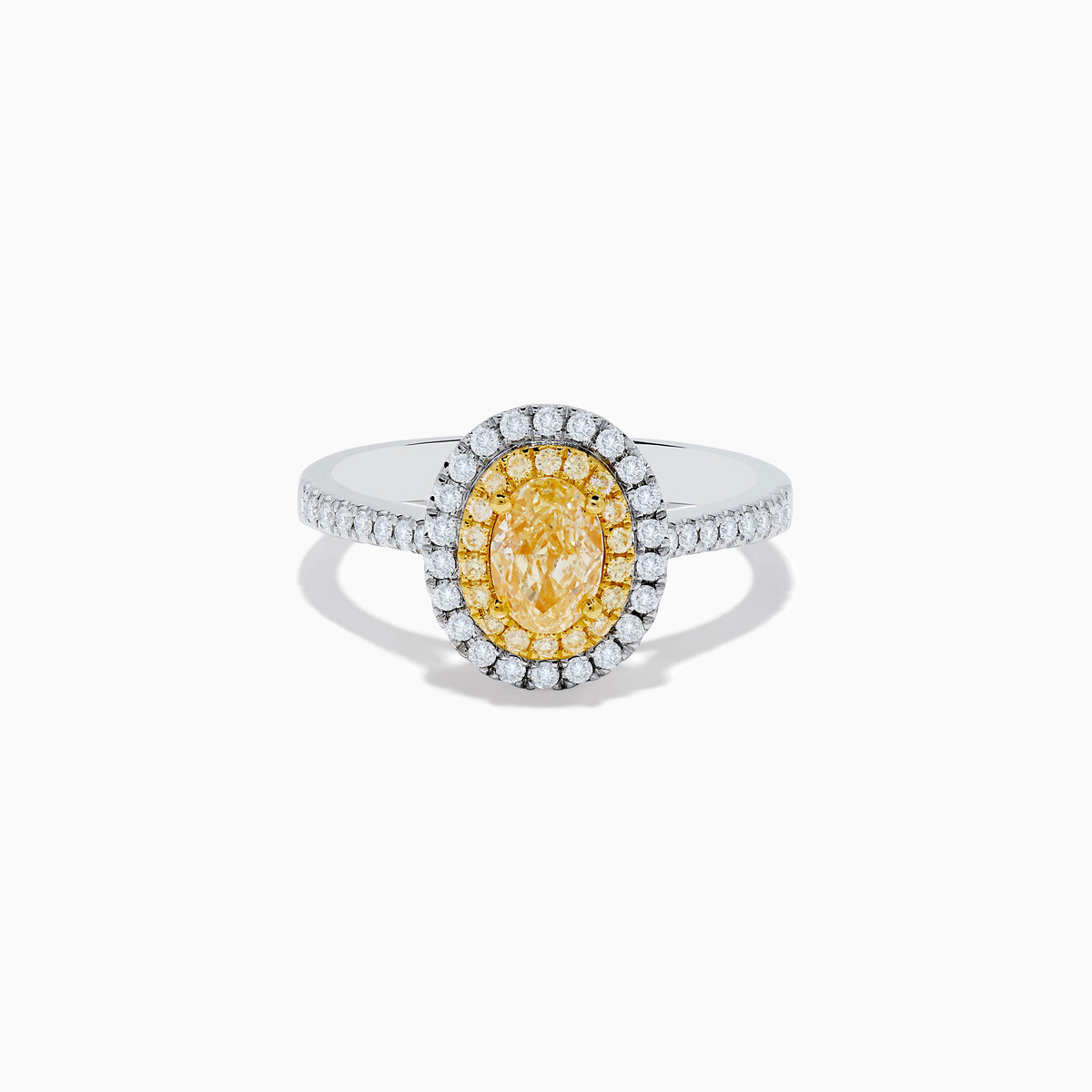 The Canare 18K Two Tone Gold White & Yellow Diamond Ring features a central oval yellow gemstone, accented by a halo of white diamonds and additional diamonds set along the band.