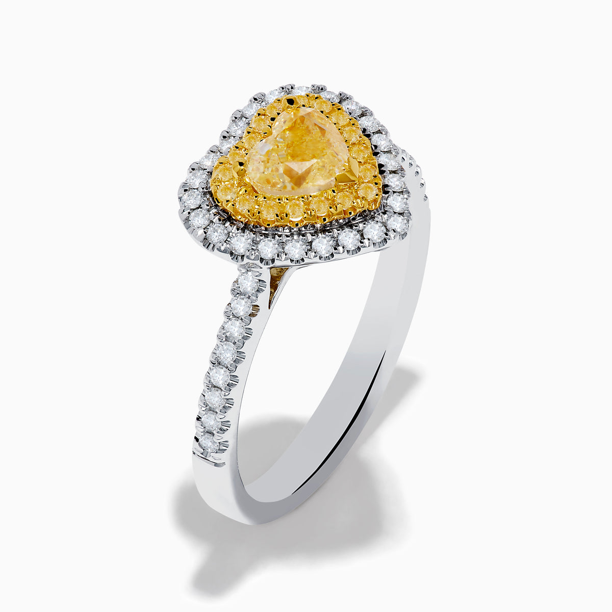 The Canare 18K Two Tone Gold White & Yellow Diamond Heart Ring features a heart-shaped yellow gemstone center with a double halo of yellow and clear diamonds, inspired by elegant Canare designs.