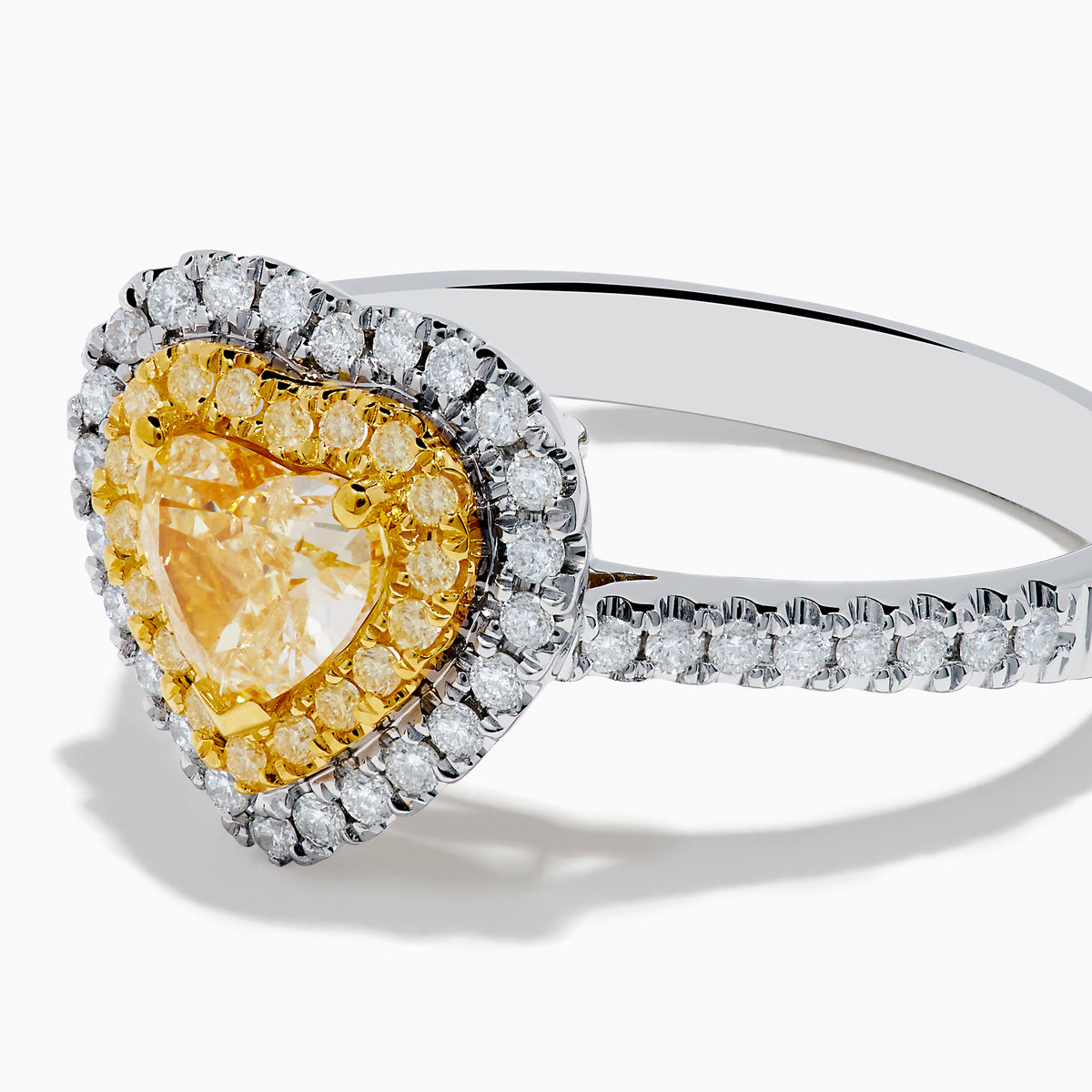 The Canare 18K Two Tone Gold White & Yellow Diamond Heart Ring features a heart-shaped yellow gemstone center with a double halo of yellow and clear diamonds, inspired by elegant Canare designs.
