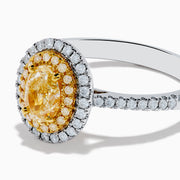 A close-up of the Canare 18K Two Tone Gold White & Yellow Diamond Ring, highlighting its oval yellow center stone encircled by two halos of white diamonds and additional diamonds set along the elegant silver band.