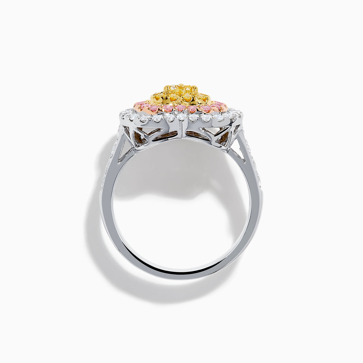 The Trio 18K Tri Color Gold White, Pink, and Yellow Diamond Heart Ring features a yellow diamond center, surrounded by pink and white diamonds on an 18K gold band for a luxurious finish.