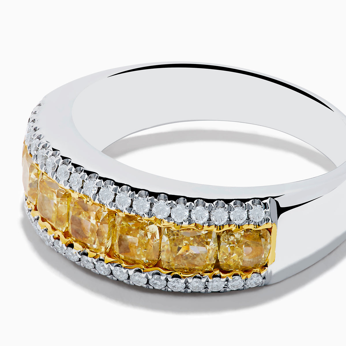 The Canare 18K Two Tone Gold White and Yellow Diamond Band Ring features a central row of yellow diamonds bordered by two rows of white diamonds, beautifully displayed on a white background.
