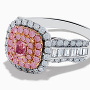 The 18K Two Tone Gold White and Pink Diamond Ring features a cushion-shaped cluster of pink diamonds at the center, encircled by a double halo of white diamonds, with more diamonds set along the band.