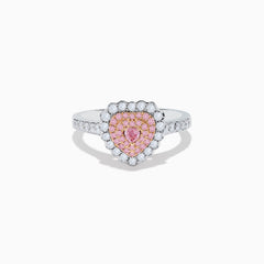 The 18K Two Tone Gold White and Pink Diamond Heart Ring features a heart design with pink diamonds at the center, white diamonds encircling the heart, and additional diamonds along the band for extra sparkle.