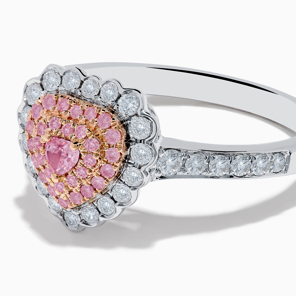 The 18K Two Tone Gold White and Pink Diamond Heart Ring features a heart design with pink diamonds at the center, white diamonds encircling the heart, and additional diamonds along the band for extra sparkle.