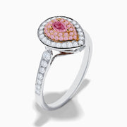 The 18K Two Tone Gold White and Pink Diamond Ring features a teardrop-shaped center with a pink gemstone, surrounded by pink and white stones, set on a band adorned with sparkling white diamonds.