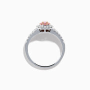 The 18K Two Tone Gold White and Pink Diamond Ring features an oval pink center gemstone, a halo of white and pink stones, and additional white stones set along the split band.