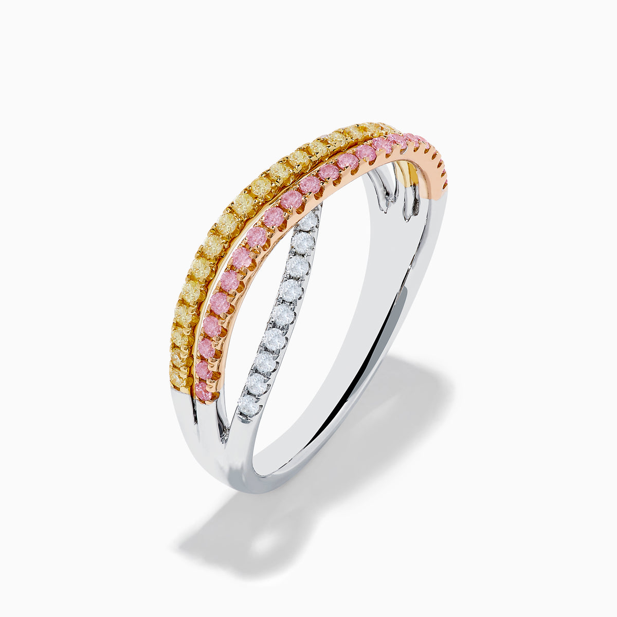The Trio 18K Gold Pink, Yellow, and White Diamond Criss Cross Ring showcases three intertwined rows with pink, yellow, and white diamonds and elegant details, all set against a white background.