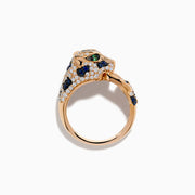 The Signature 14K Rose Gold Diamond, Sapphire and Emerald Ring features a panther’s head encrusted with white diamonds, blue sapphires, and green emeralds, with the panther biting a ring in its mouth.