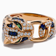 The Signature 14K Rose Gold Diamond, Sapphire and Emerald Ring features a panther’s head encrusted with white diamonds, blue sapphires, and green emeralds, with the panther biting a ring in its mouth.