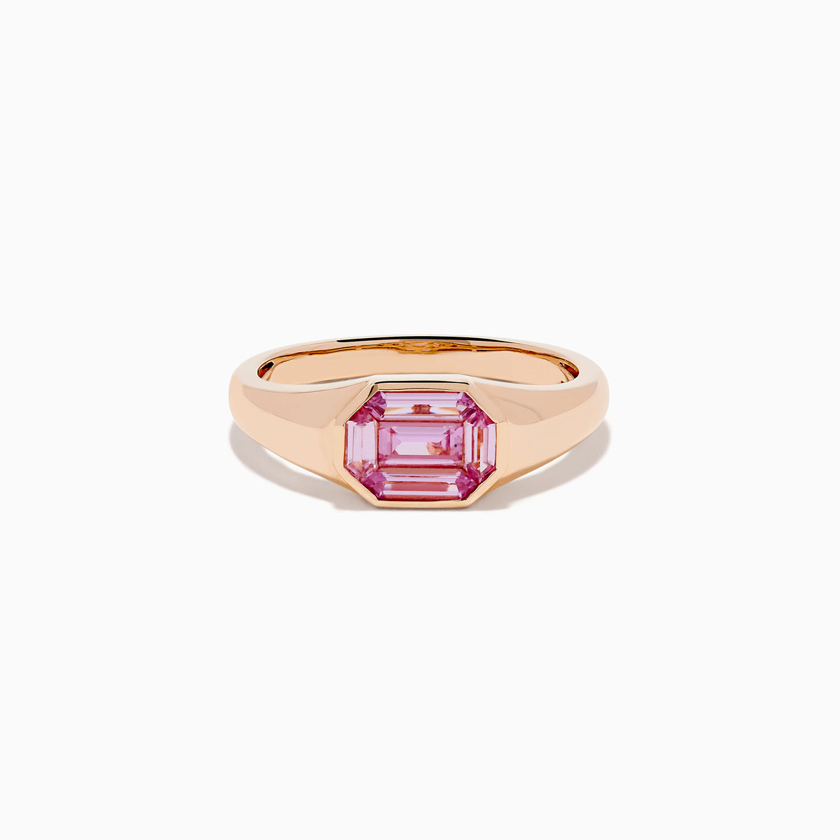 The 14K Rose Gold Bezel Set Pink Sapphire Ring showcases an emerald-cut pink sapphire in a bezel setting, presented on a white background.