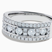 The 14K White Gold Channel Set Diamond Wide Band Ring features three rows of round diamonds, with five larger channel-set stones in the center and smaller diamonds on either side, creating an elegant, eye-catching look.