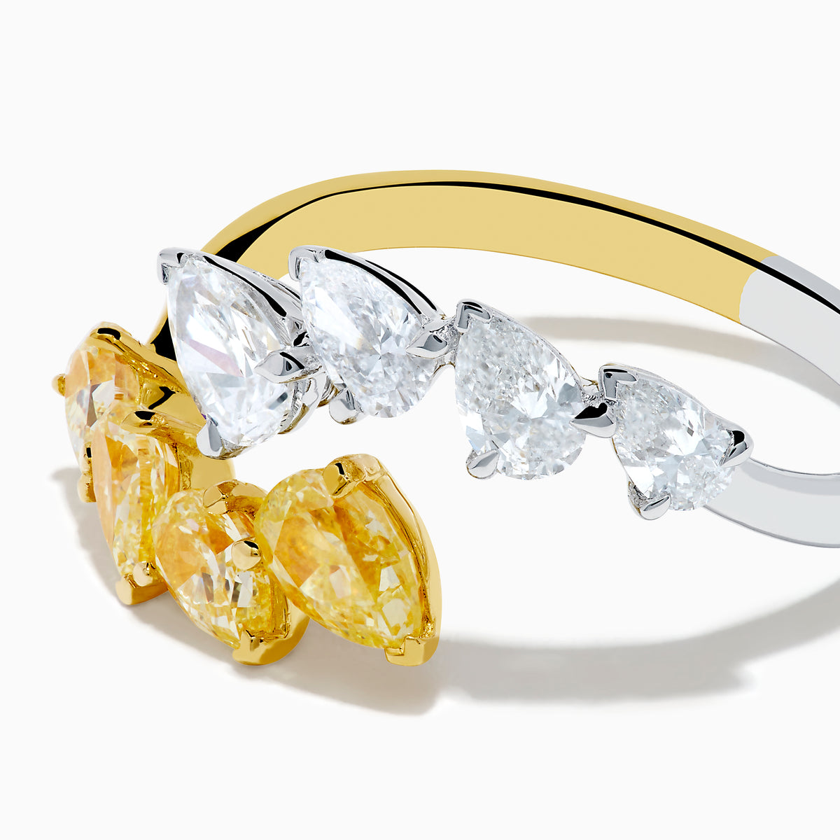 The Canare 18K Two Tone Gold White & Yellow Diamond Bypass Ring showcases three yellow pear-shaped diamonds on one side and three white pears on the other, displayed against a simple white background.