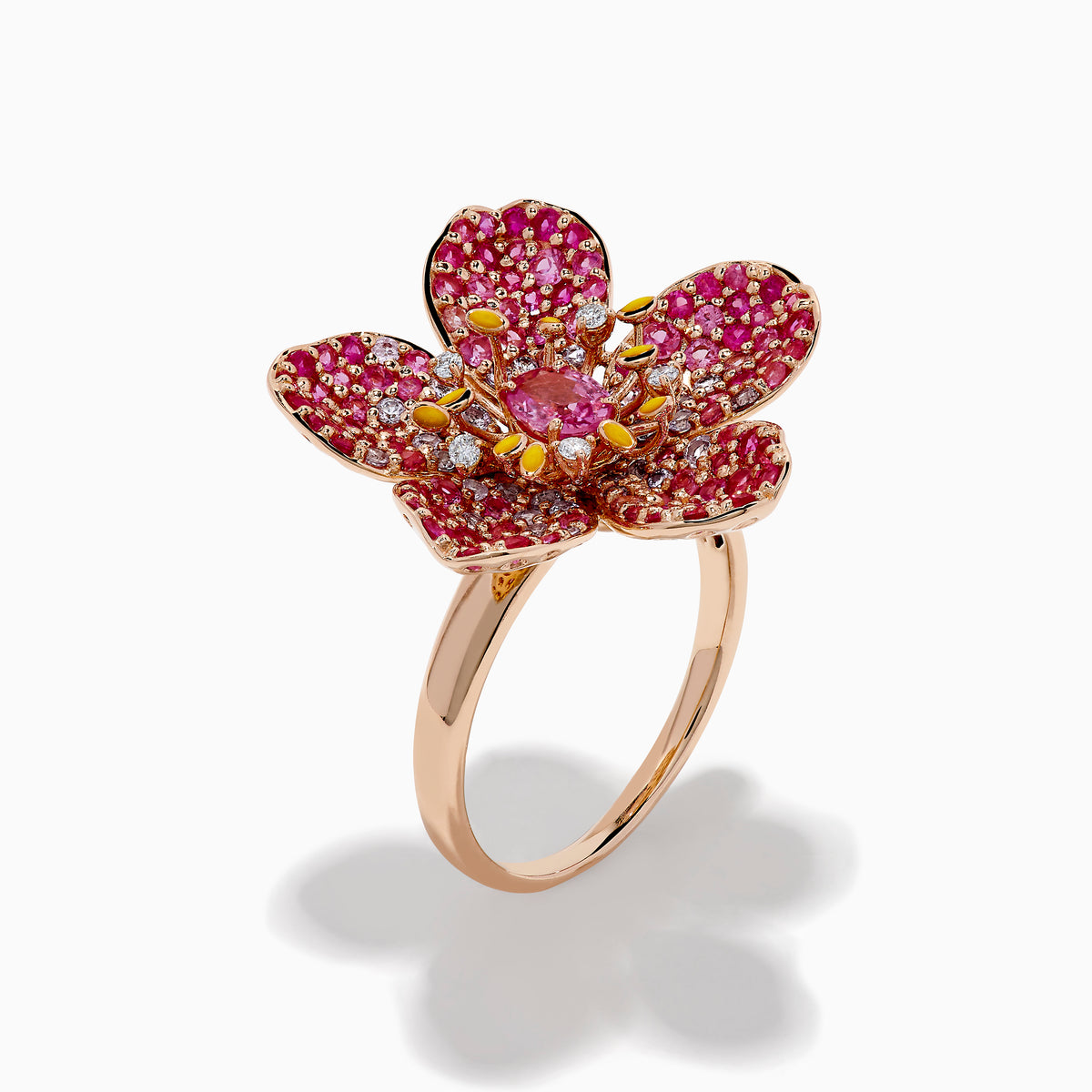 The Nature 14K Rose Gold Pink Sapphire and Diamond Flower Ring features a floral design with five petals, small pink and red gemstones, a central oval pink sapphire, and shimmering rose gold outlining for added sparkle.