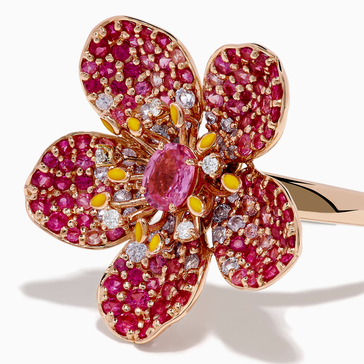 The Nature 14K Rose Gold Pink Sapphire and Diamond Flower Ring features a floral design with five petals, small pink and red gemstones, a central oval pink sapphire, and shimmering rose gold outlining for added sparkle.