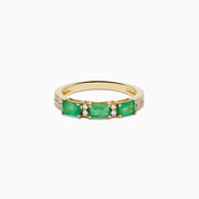 The 14K Yellow Gold Emerald and Diamond Band showcases three rectangular green emeralds set horizontally, each separated by small round diamonds, with extra diamond accents on the sides.