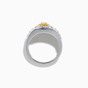 The Men's 18K Two Tone Gold Yellow and White Diamond Signet Ring showcases an oval yellow gemstone at the center, framed by a halo of clear diamonds, with rows of yellow stones along each side of the band.