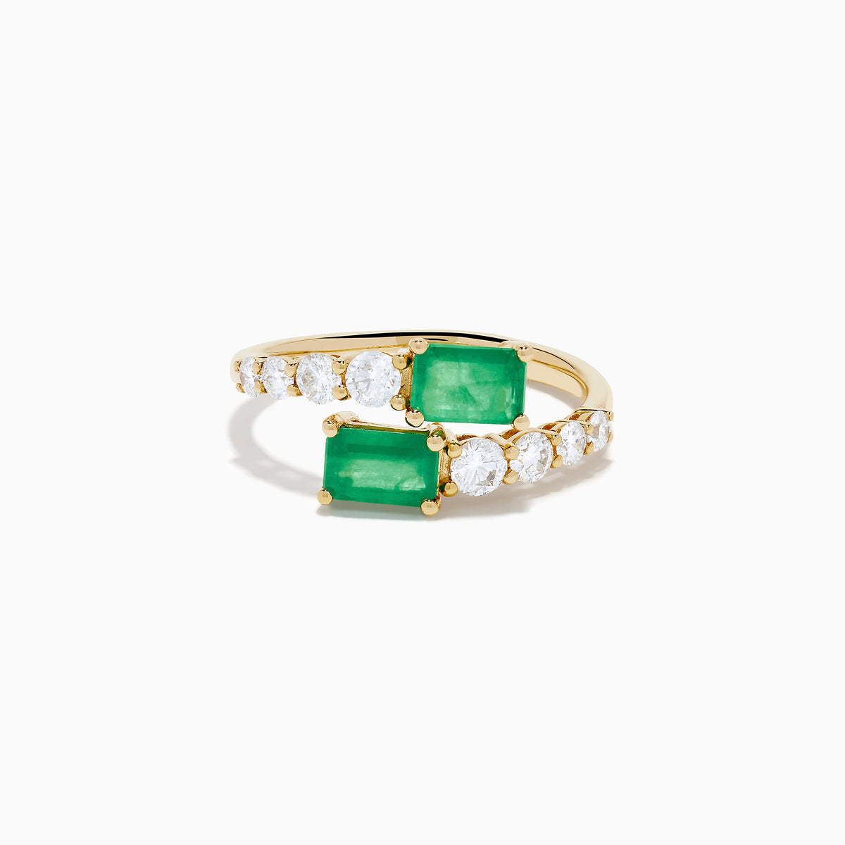 The 14K Yellow Gold Diamond and Emerald Bypass Ring features two rectangular green emeralds and rows of sparkling round white diamonds on each side in an open band design, set against a white background.