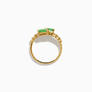 The 14K Yellow Gold Diamond and Emerald Bypass Ring features two rectangular green emeralds and rows of sparkling round white diamonds on each side in an open band design, set against a white background.