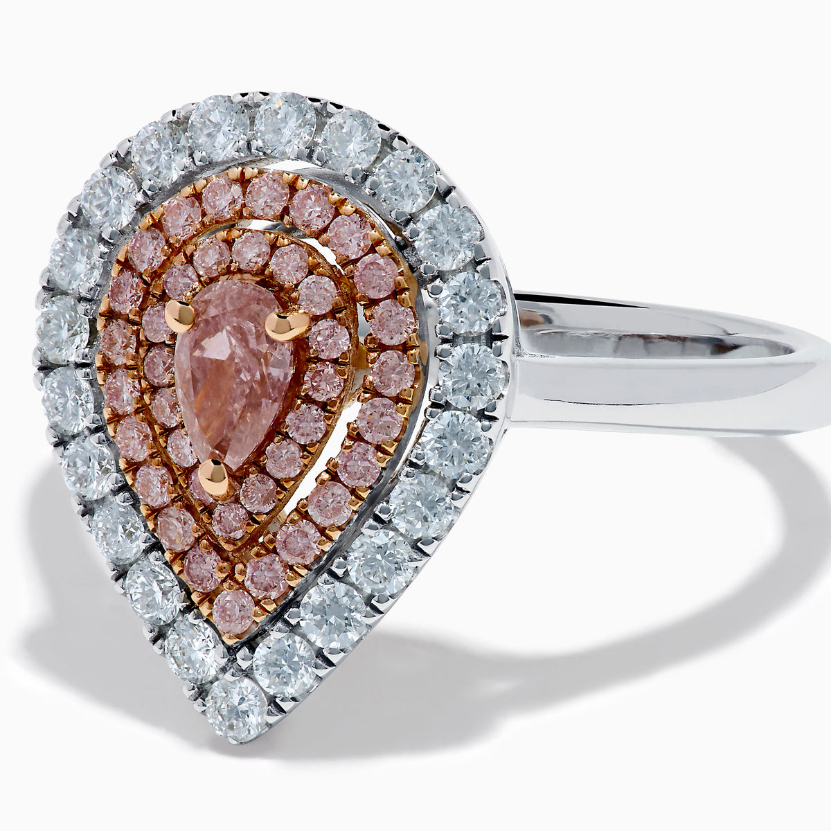 The 18K Two Tone Pear Shape Pink and White Diamond Halo Ring showcases a pear-shaped center, double halos of pink and white diamonds, and a slim two-tone band, set against a white background.